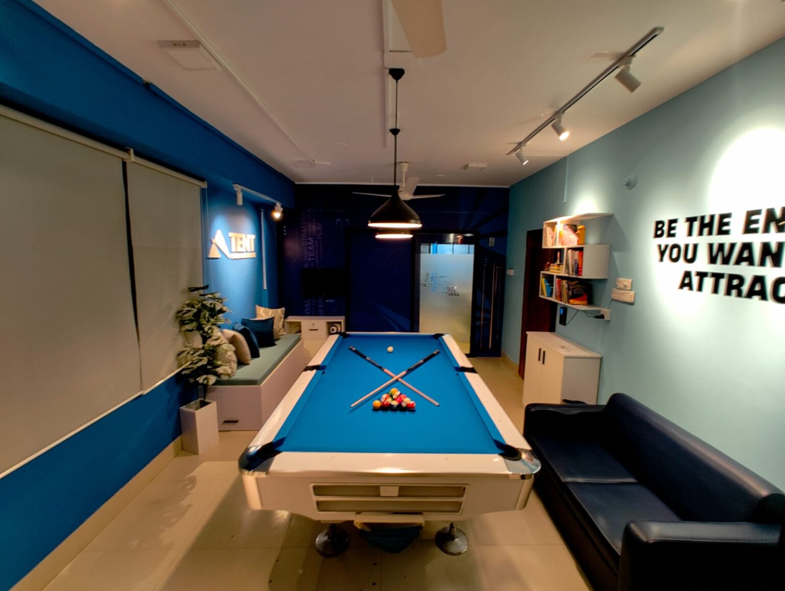 Tent Communications office lounge with a blue pool table and brand wall